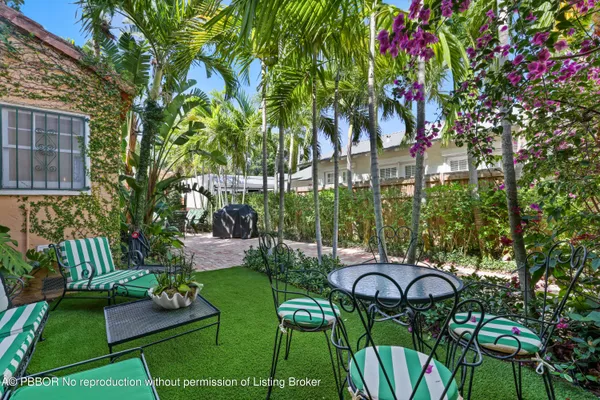 a view of backyard with outdoor seating and plants