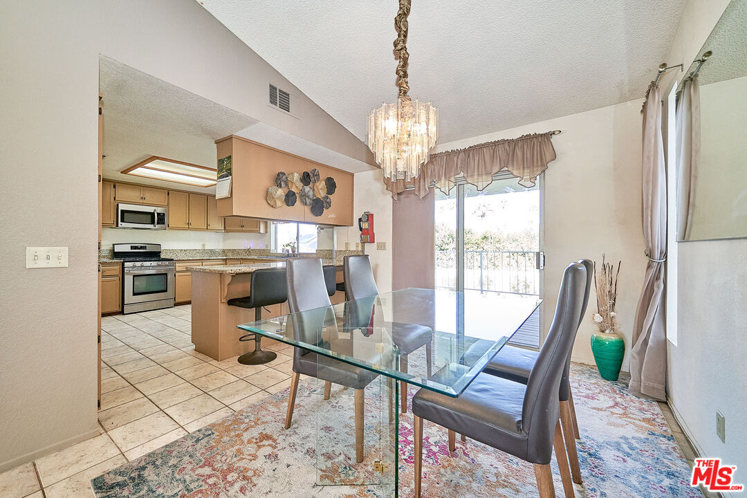 68920 Minerva Road Cathedral City, CA 92234 - Photo 13 of 49 a view of a dining room with furniture a chandelier and wooden floor
