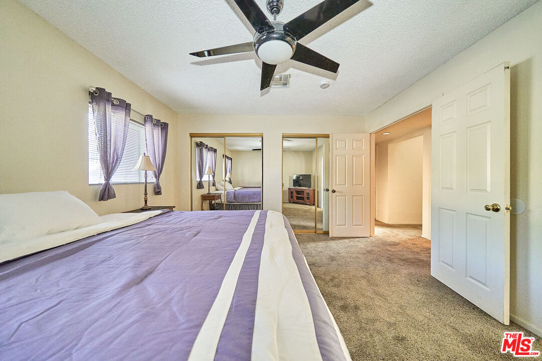 68920 Minerva Road Cathedral City, CA 92234 - Photo 32 of 49 a spacious bedroom with a bed and a chandelier