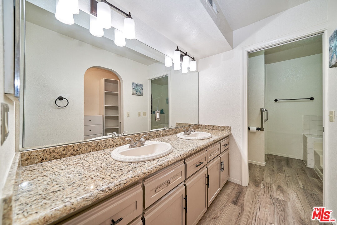 68920 Minerva Road Cathedral City, CA 92234 - Photo 34 of 49 a spacious bathroom with a granite countertop sink a mirror and a shower