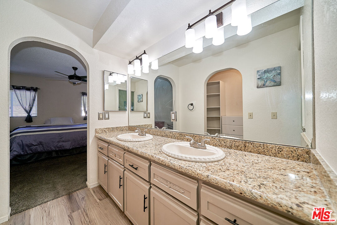 68920 Minerva Road Cathedral City, CA 92234 - Photo 35 of 49 a spacious bathroom with a granite countertop sink and a mirror