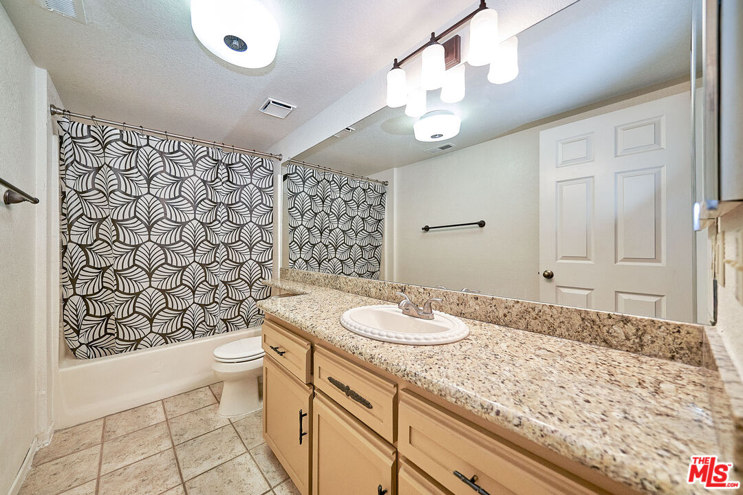68920 Minerva Road Cathedral City, CA 92234 - Photo 39 of 49 a bathroom with a granite countertop sink a toilet and a shower