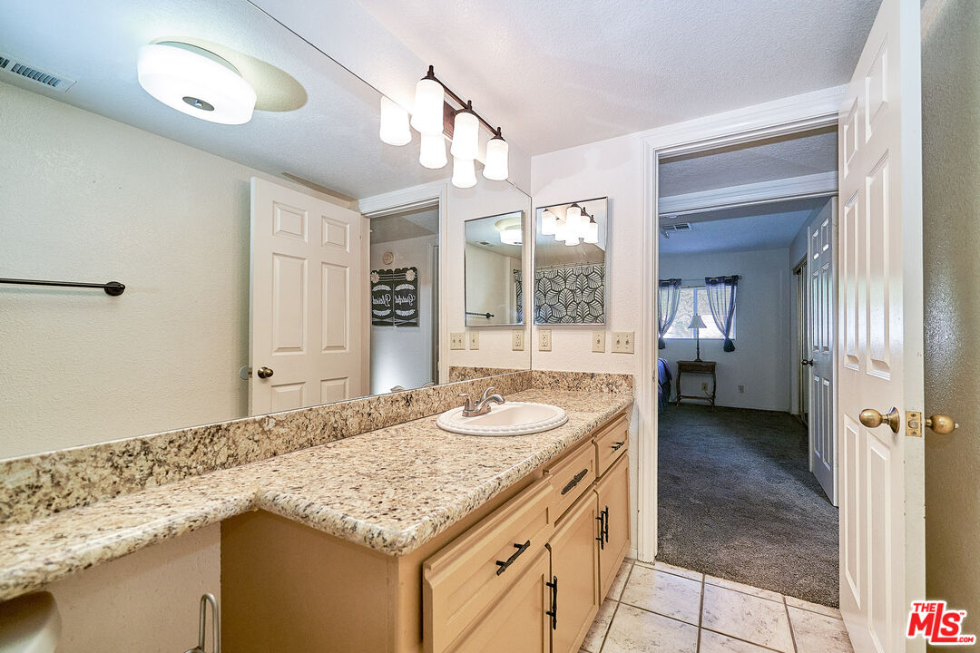 68920 Minerva Road Cathedral City, CA 92234 - Photo 43 of 49 a bathroom with a granite countertop sink and a mirror