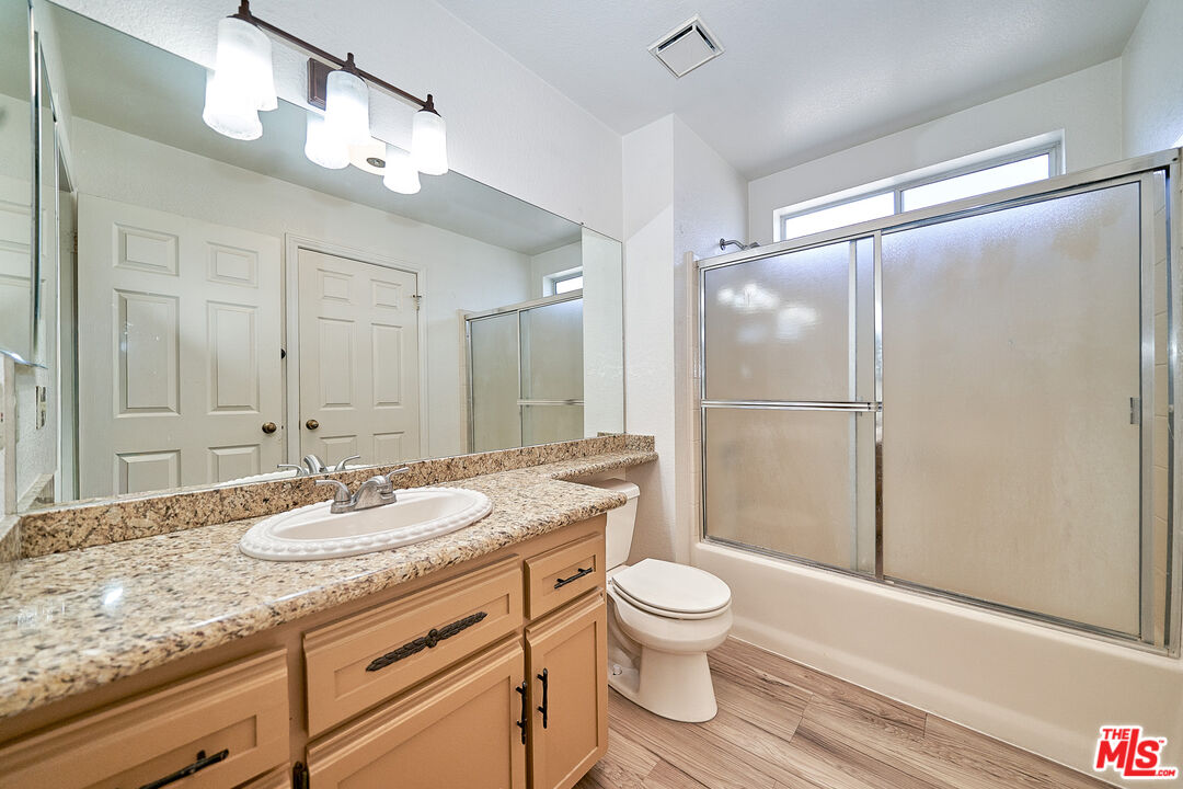 68920 Minerva Road Cathedral City, CA 92234 - Photo 44 of 49 a bathroom with a granite countertop sink toilet a mirror and shower