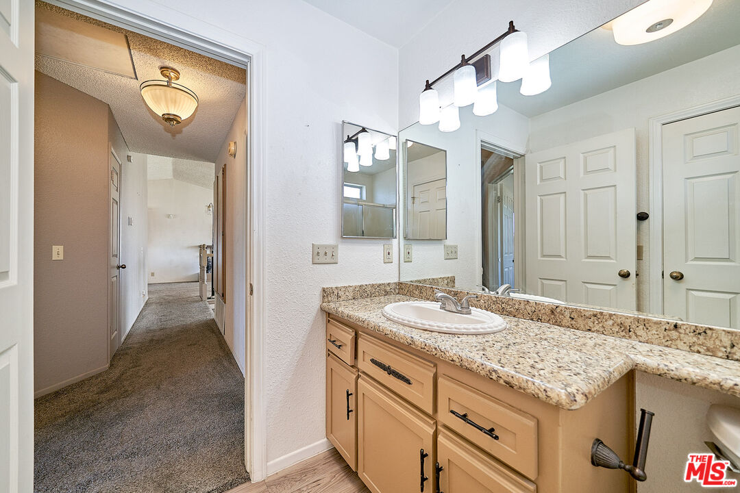 68920 Minerva Road Cathedral City, CA 92234 - Photo 45 of 49 a bathroom with a granite countertop sink and a mirror