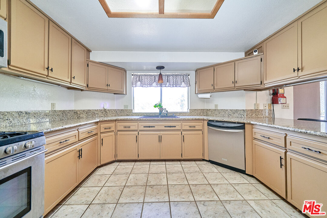 68920 Minerva Road Cathedral City, CA 92234 - Photo 10 of 49 a kitchen with a sink window and cabinets