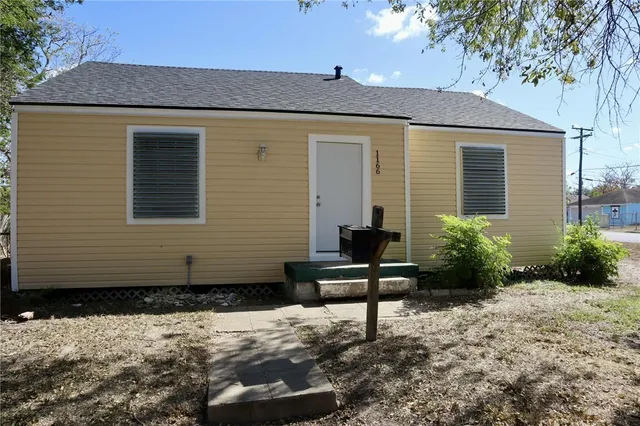 a backyard of a house with potted plants and trees