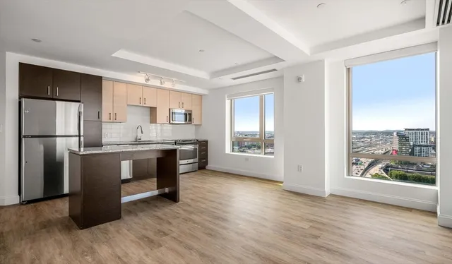 a kitchen with kitchen island wooden floors appliances and counter space