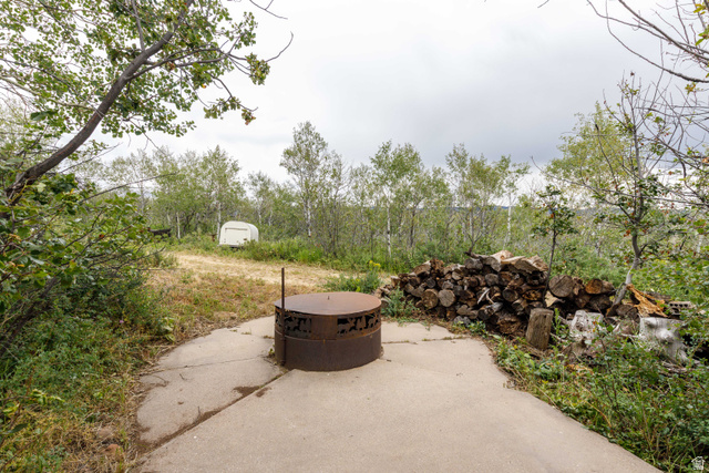 23 Scare Canyon, Unit 23 Logan, UT 84321 - Photo 23 of 33 Concrete patio featuring a built-in fire pit and a stacked woodpile
