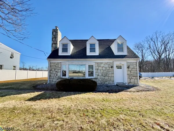 a front view of a house with a yard covered in snow