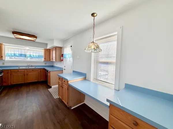 a bathroom with a granite countertop sink toilet a large mirror and a window
