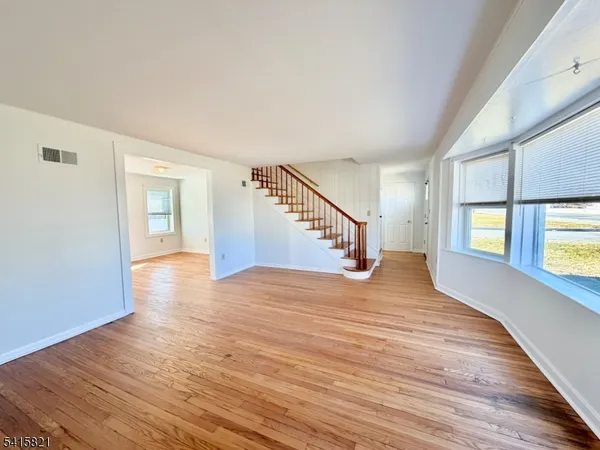 a view of an empty room with window and fireplace