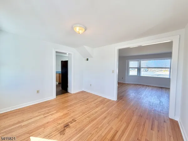 a view of an empty room with window and closet area