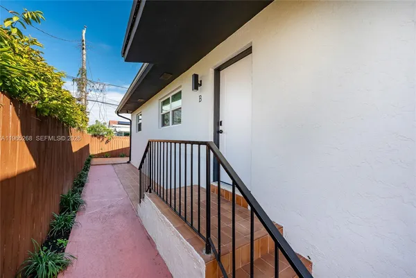 a view of a pathway of a house with wooden fence