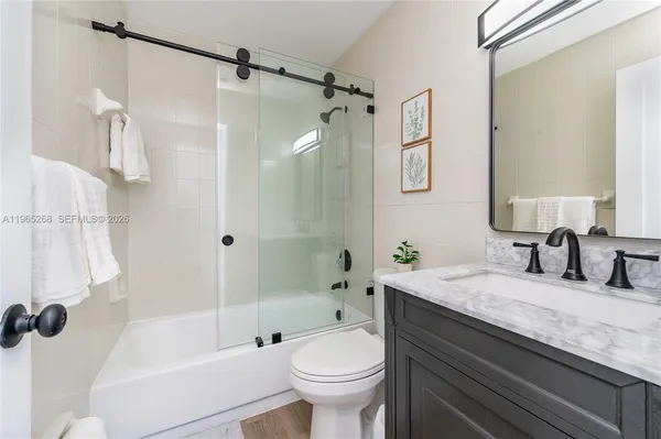 a bathroom with a granite countertop toilet a sink and a bathtub