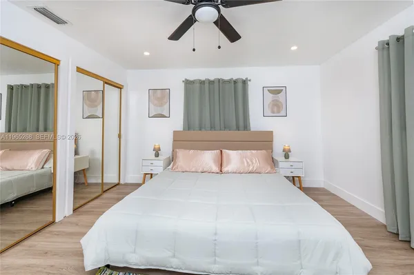 a bedroom with a large bed and a chandelier