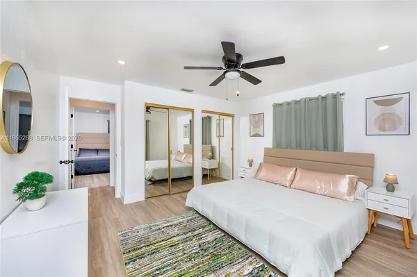 a bedroom with a large bed and ceiling fan