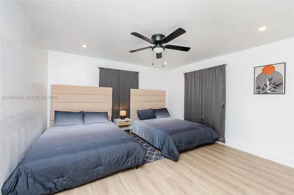a bedroom with two beds and painting on the wall
