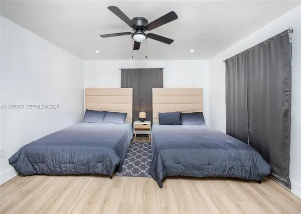 a bedroom with a large bed and ceiling fan