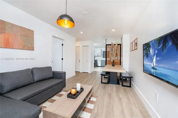 a living room with furniture and kitchen view