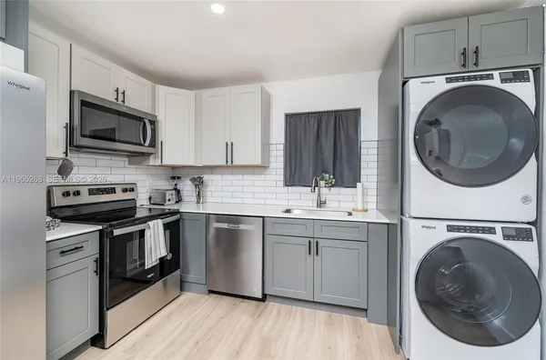 a kitchen with stainless steel appliances a stove a sink and a microwave