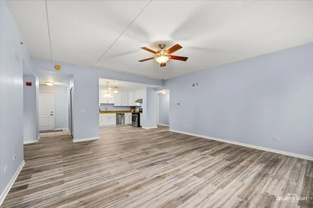 a view of an empty room with window and a ceiling fan
