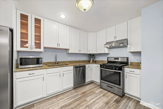 a kitchen with stainless steel appliances granite countertop a stove and a sink