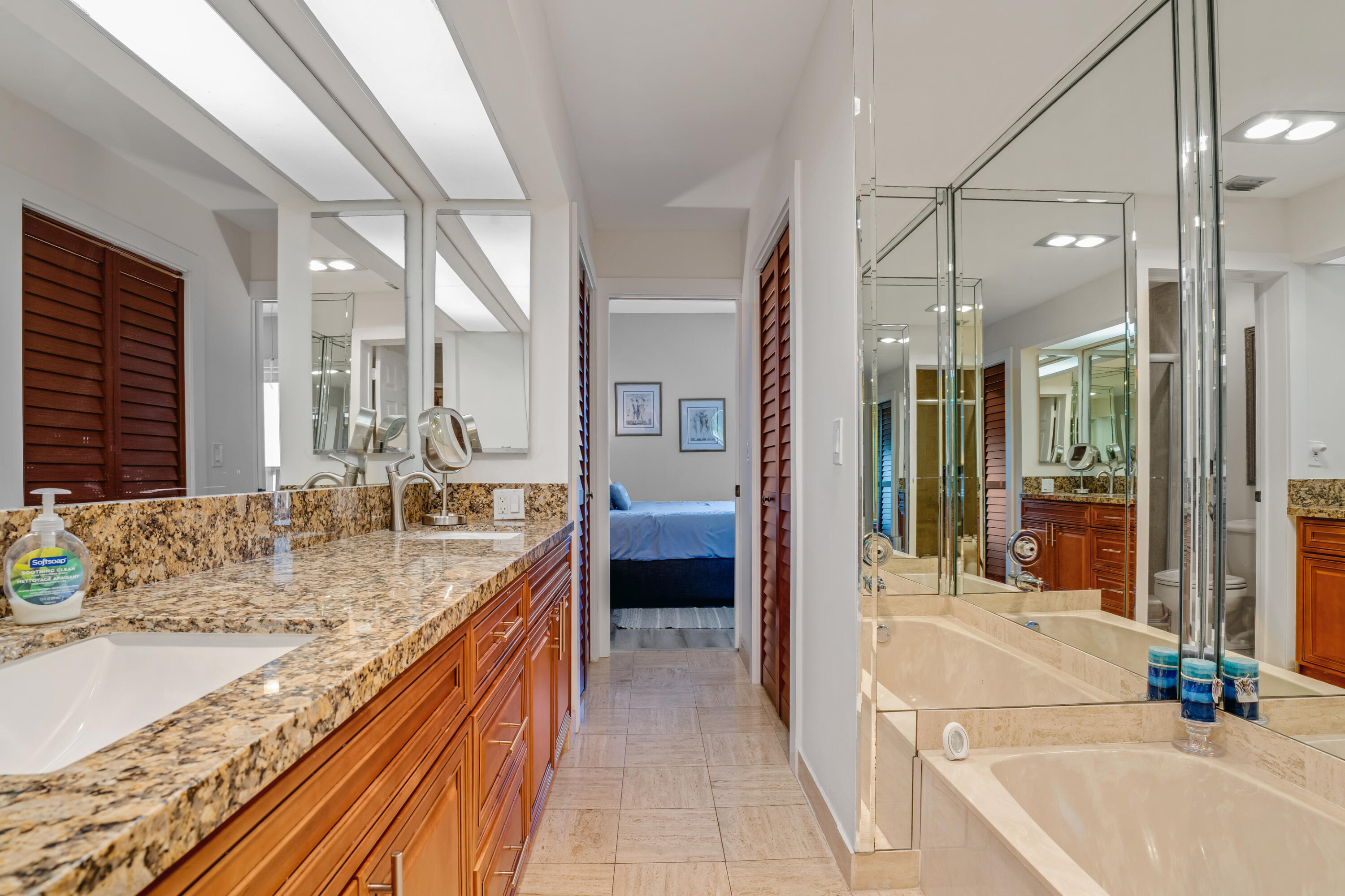 7472 La Paz Boulevard, Unit 102 Boca Raton, FL 33433 - Photo 13 of 14 a bathroom with a granite countertop sink mirror and shower