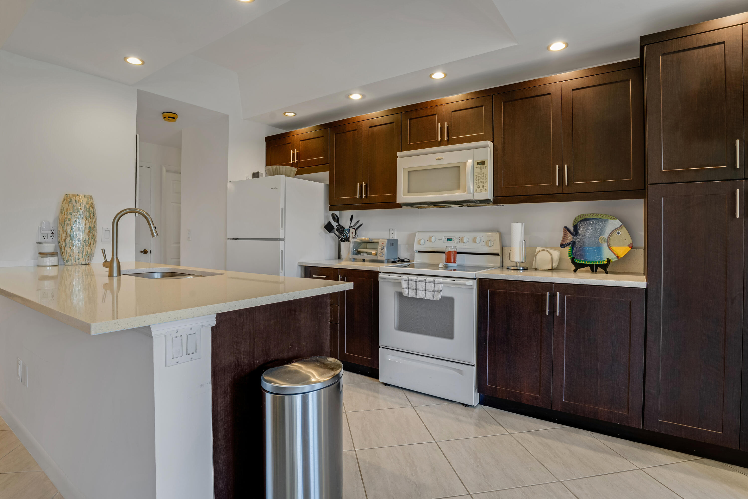 7472 La Paz Boulevard, Unit 102 Boca Raton, FL 33433 - Photo 5 of 14 a kitchen with a sink cabinets and appliances
