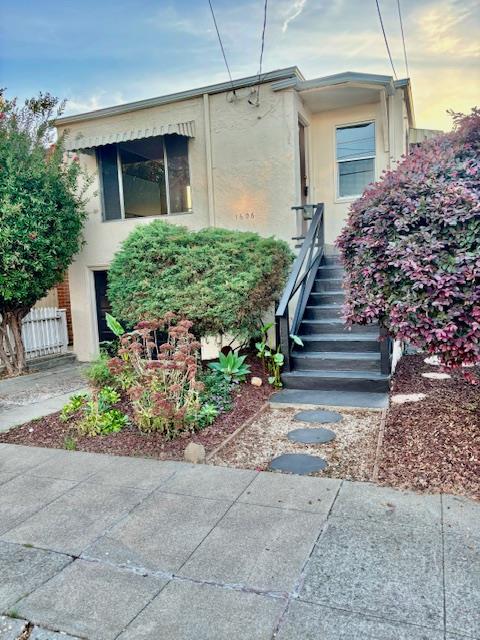 a view of a pathway of house with potted plants