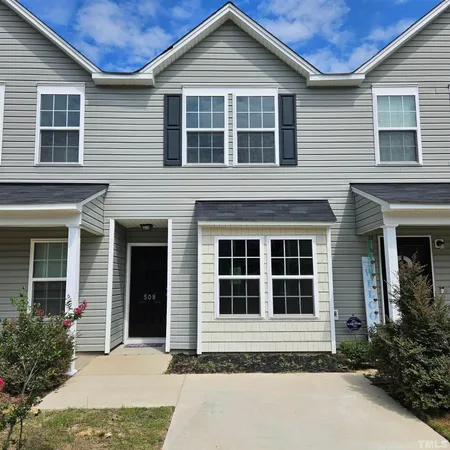 a front view of a house with a yard and outdoor seating