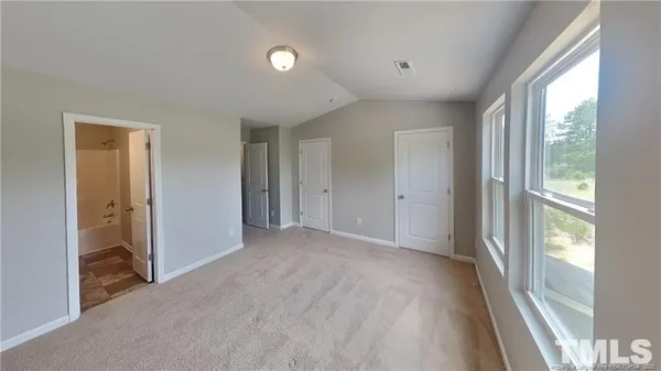 a view of empty room with windows and refrigerator