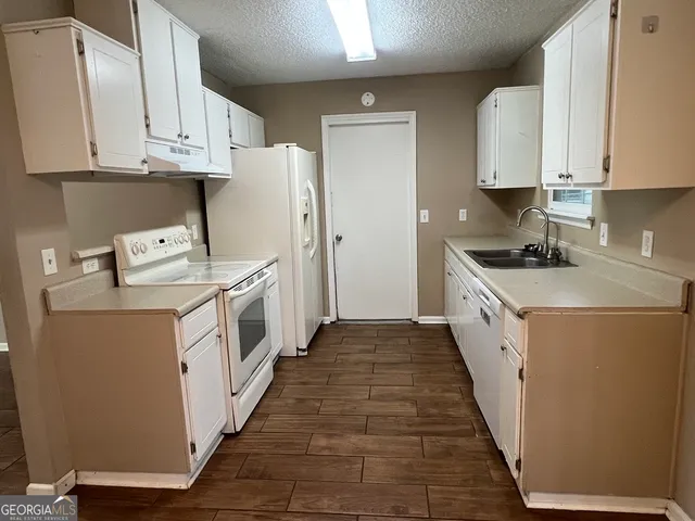 a kitchen with white cabinets and white appliances