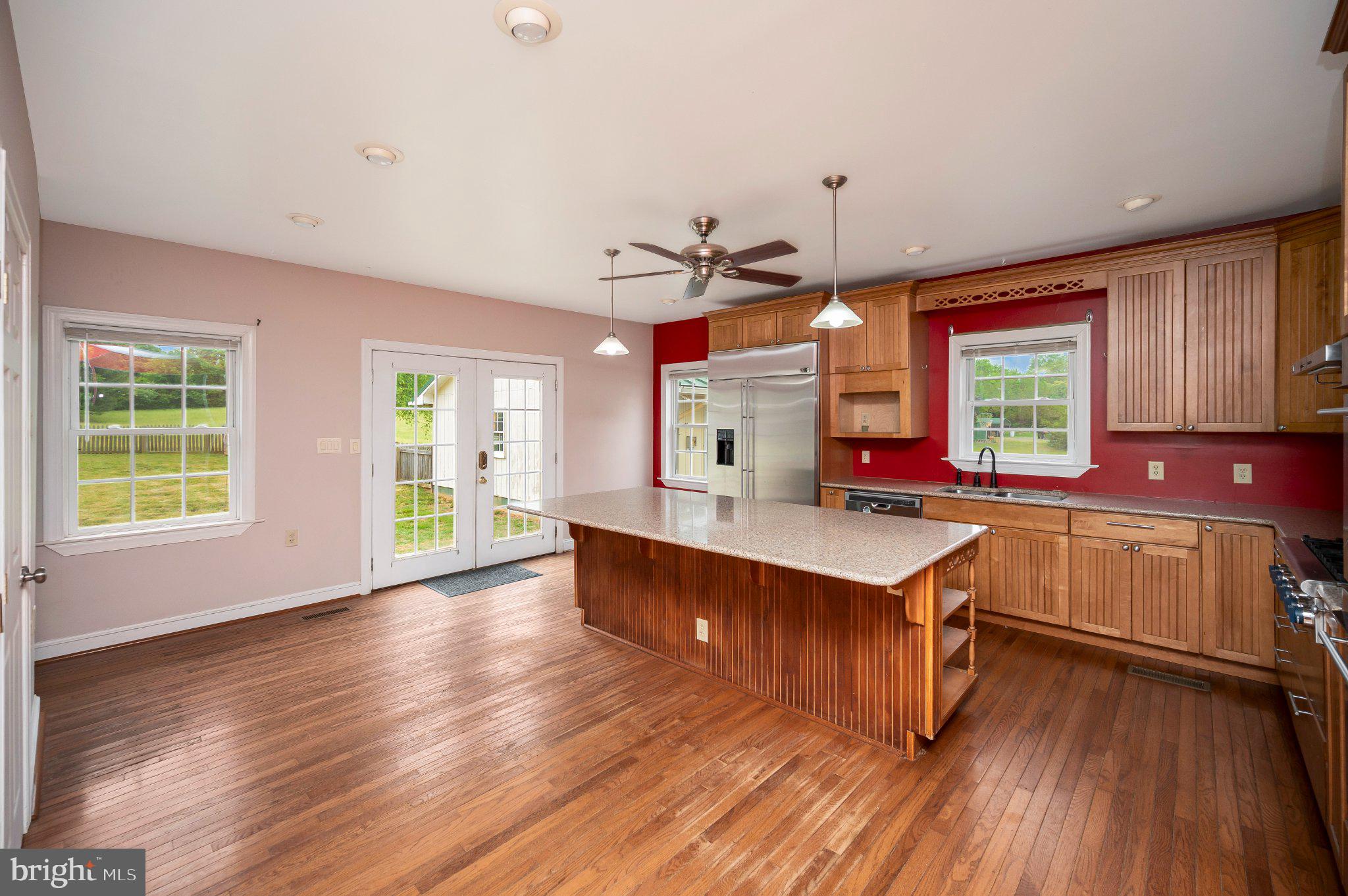 23202 Village Road Unionville, VA 22567 - Photo 21 of 58 a kitchen with kitchen island granite countertop a stove a sink and wooden floors