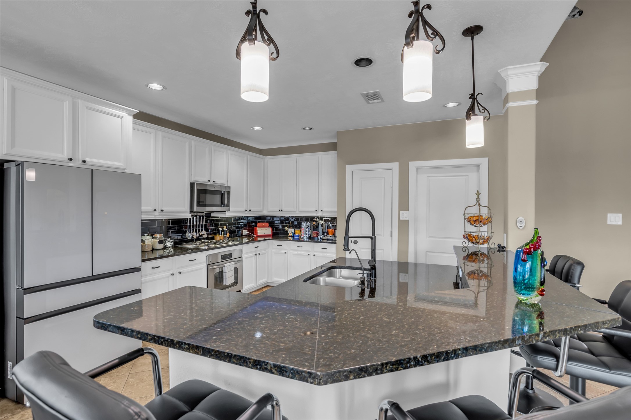 12602 Spellbrook Point Lane Tomball, TX 77377 - Photo 27 of 47 a kitchen with stainless steel appliances granite countertop a sink dishwasher a dining table and chairs with wooden floor