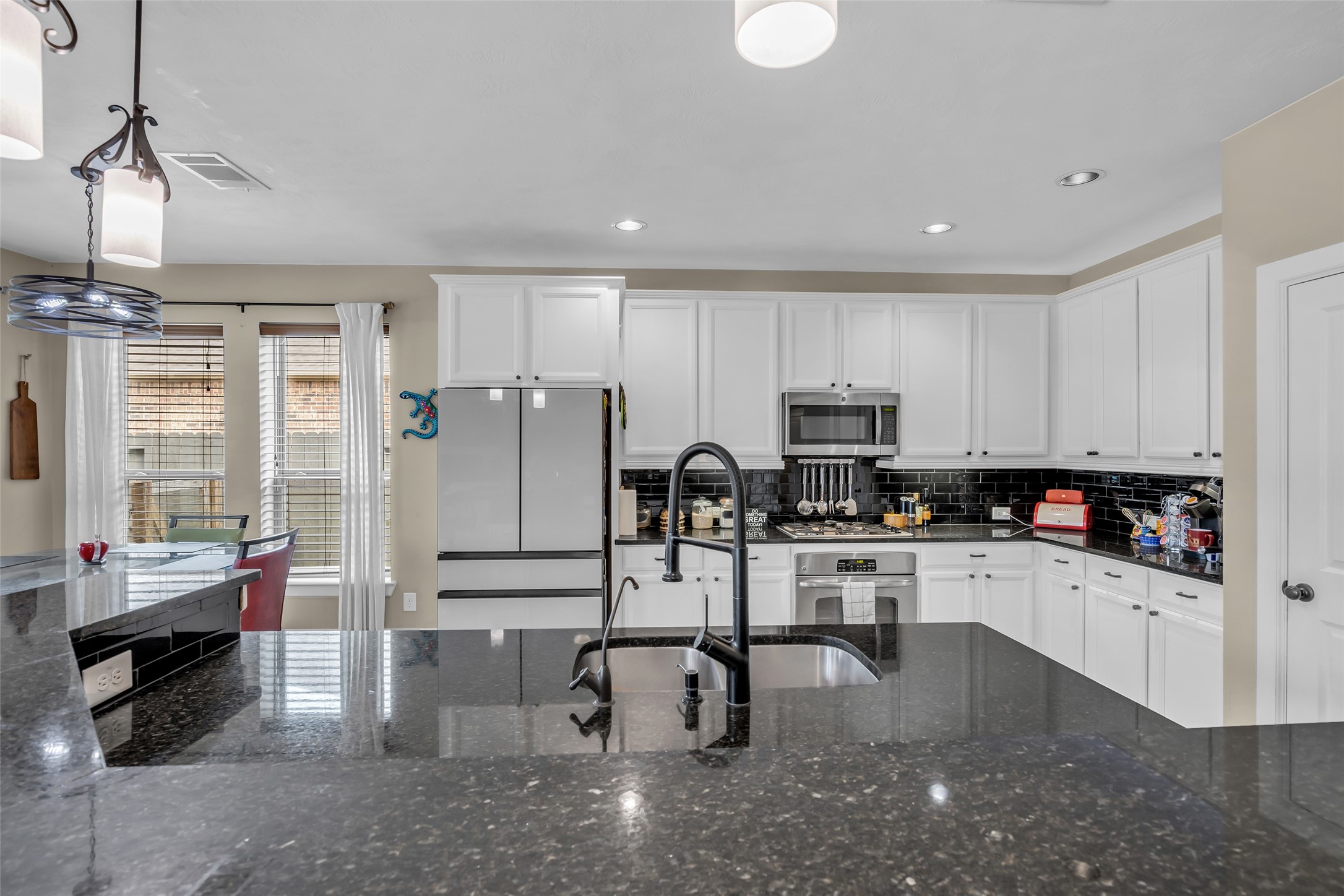 12602 Spellbrook Point Lane Tomball, TX 77377 - Photo 29 of 47 a kitchen with stainless steel appliances granite countertop a stove top oven a refrigerator a sink and white cabinets