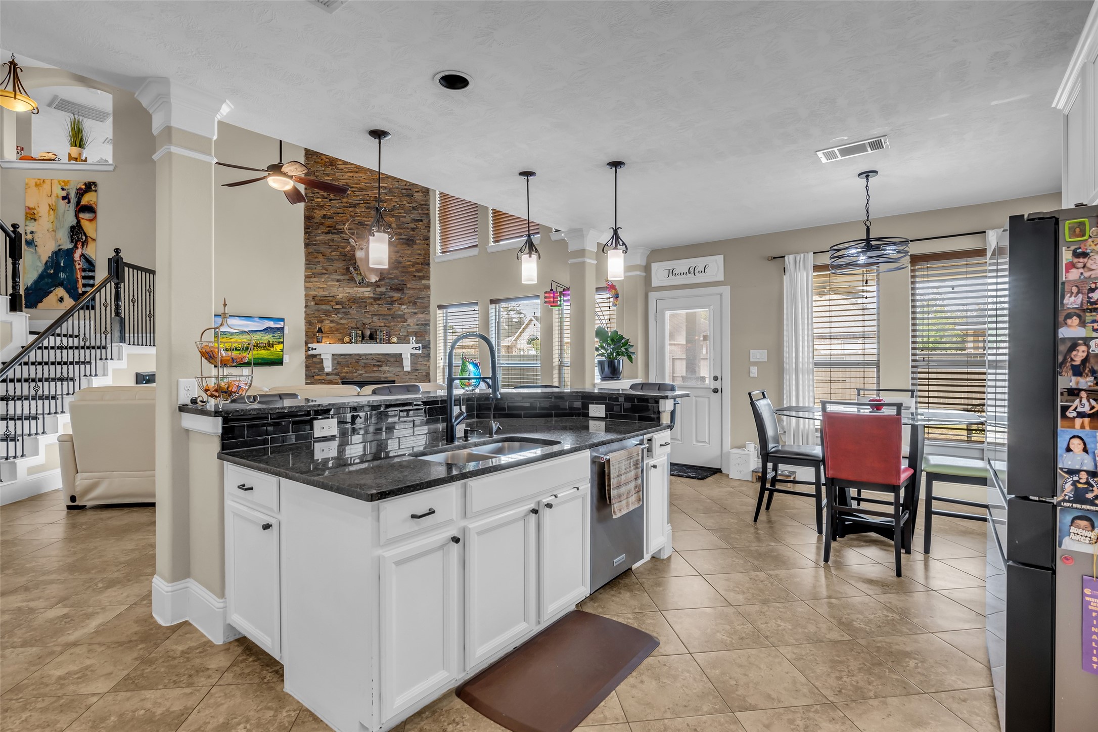 12602 Spellbrook Point Lane Tomball, TX 77377 - Photo 32 of 47 a kitchen with a dining table chairs sink and white cabinets