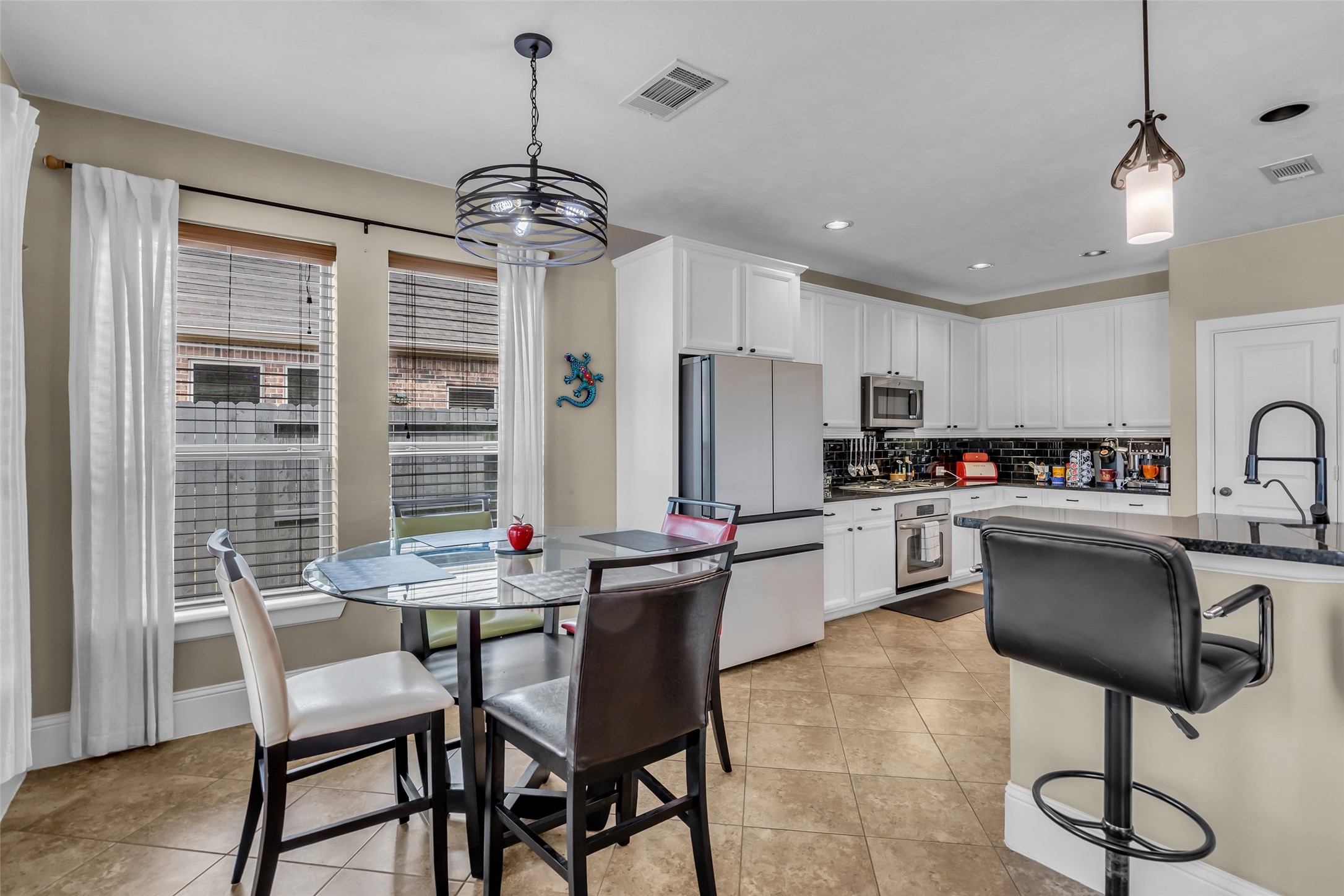 12602 Spellbrook Point Lane Tomball, TX 77377 - Photo 33 of 47 a kitchen with a dining table chairs sink and refrigerator
