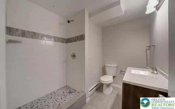 a bathroom with a sink a toilet and shower