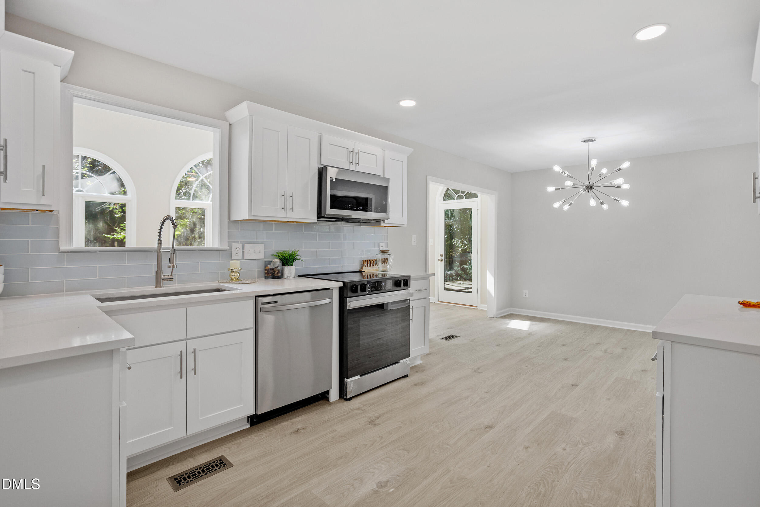 1103 Suterland Road Cary, NC 27511 - Photo 10 of 21 a kitchen with kitchen island granite countertop a sink cabinets and stainless steel appliances
