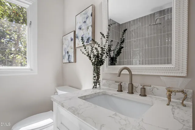 a bathroom with a granite countertop sink a toilet and with mirror