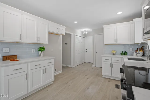 a kitchen with white cabinets and white appliances