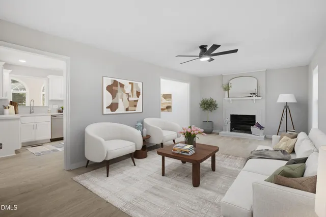 a living room with furniture a fireplace and a chandelier