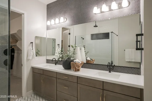 a bedroom with two bed and a lamp on dresser