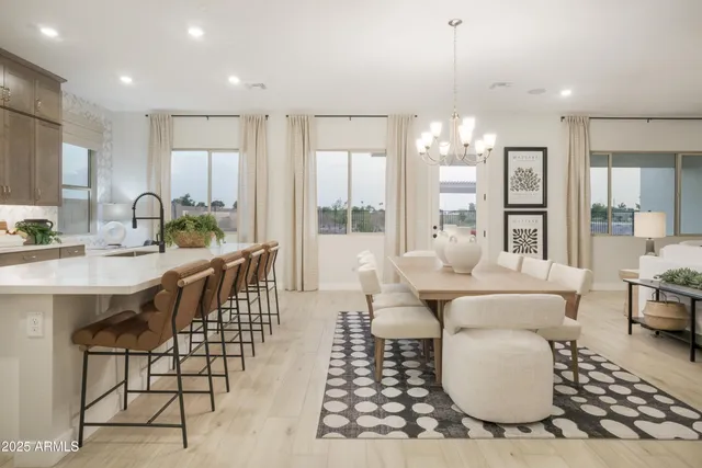 a kitchen with stainless steel appliances granite countertop a sink a stove a refrigerator cabinets and dining table