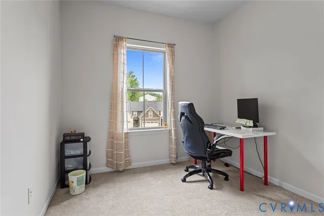 a view of a workspace with furniture and a window