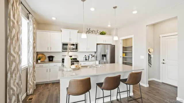 a kitchen with stainless steel appliances kitchen island granite countertop a refrigerator and microwave