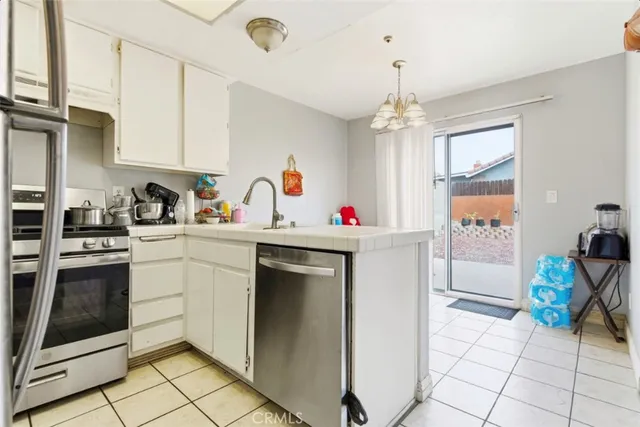 a utility room with refrigerator and cabinets