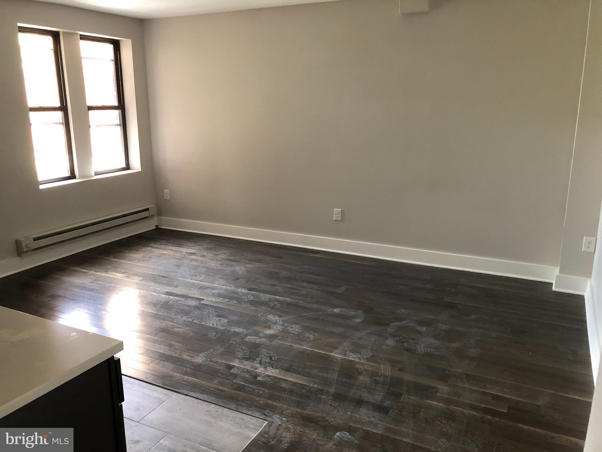 5101-7 North 12th Street, Unit 6C Philadelphia, PA 19141 - Photo 1 of 3 an empty room with wooden floor and windows