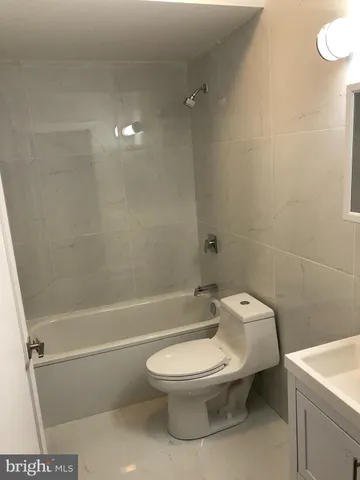 a white toilet sitting next to a bath tub